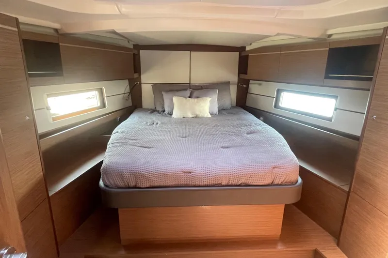 Dire Wolf Yacht Photos Pics Luxurious cabin interior of 2020 Beneteau Oceanis 46.1 yacht with cozy bed and wooden finish.