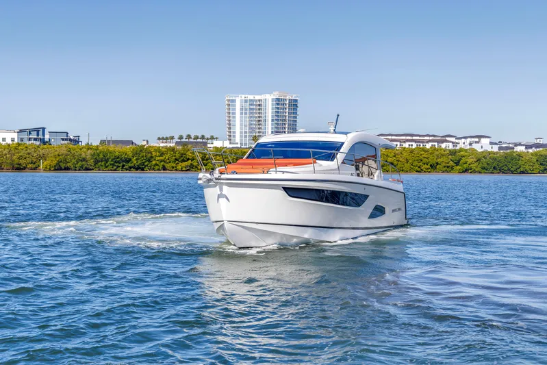  Yacht Photos Pics 2020 Sealine C390 yacht cruising on a sunny day near modern waterfront buildings.