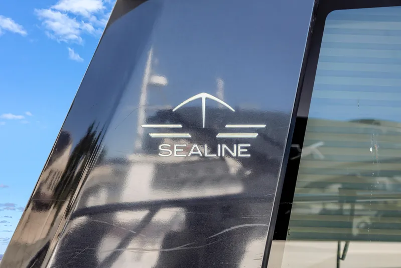  Yacht Photos Pics Sealine C390 2020 yacht logo on sleek black surface with blue sky background.