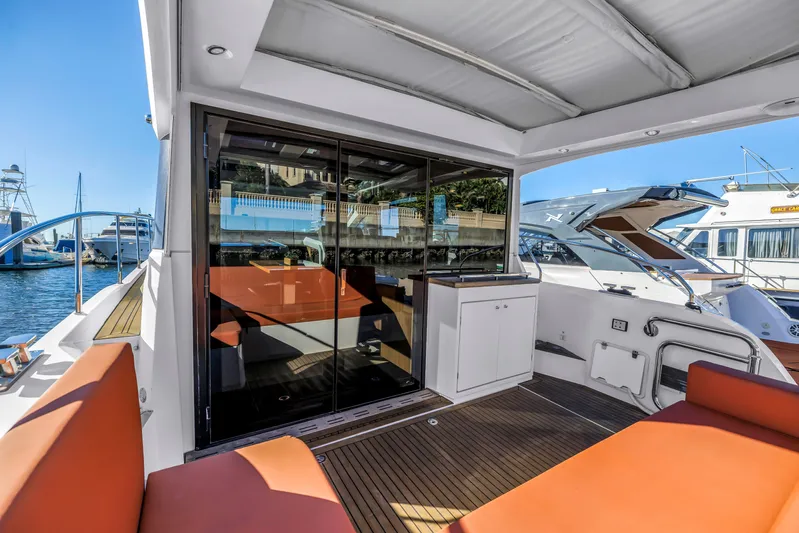  Yacht Photos Pics 2020 Sealine C390 yacht with spacious deck, orange seating, and modern design in marina setting.