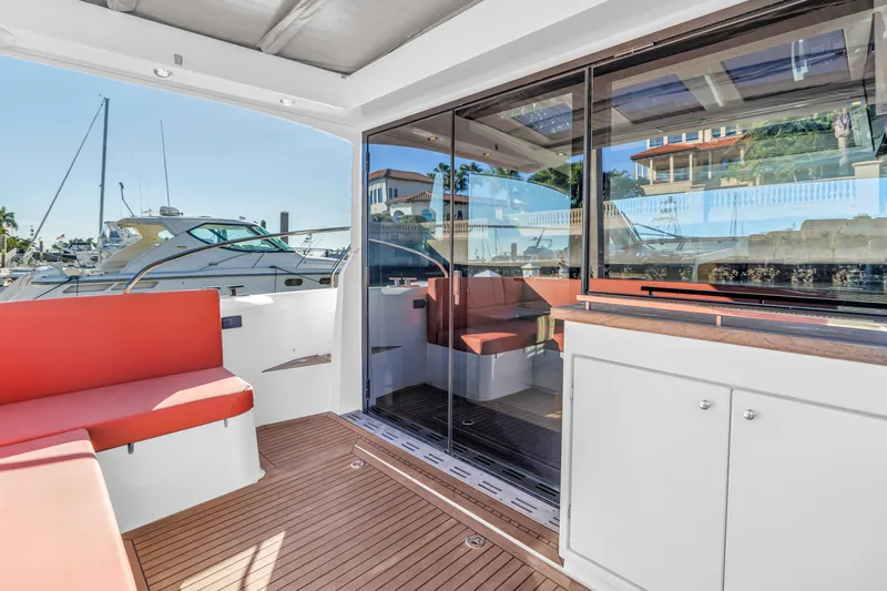  Yacht Photos Pics 2020 Sealine C390 yacht interior with red seating and wooden flooring at a marina.