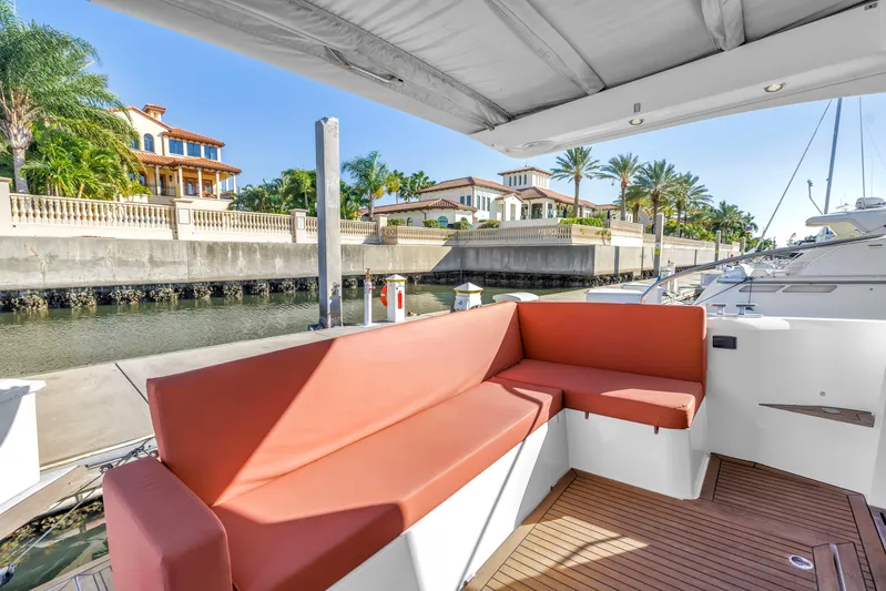  Yacht Photos Pics 2020 Sealine C390 yacht with red seating, docked near luxury waterfront homes.