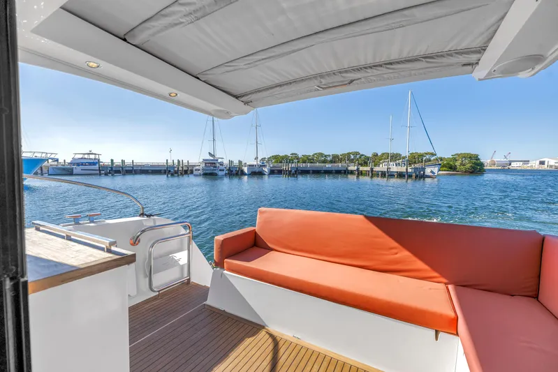  Yacht Photos Pics 2020 Sealine C390 yacht with orange seating, docked at a marina under clear blue skies.