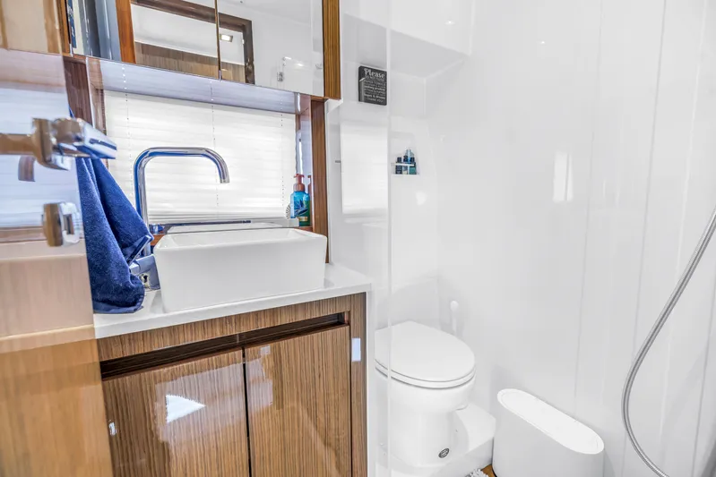  Yacht Photos Pics Modern bathroom in 2020 Sealine C390 yacht with sleek fixtures and wooden cabinetry.