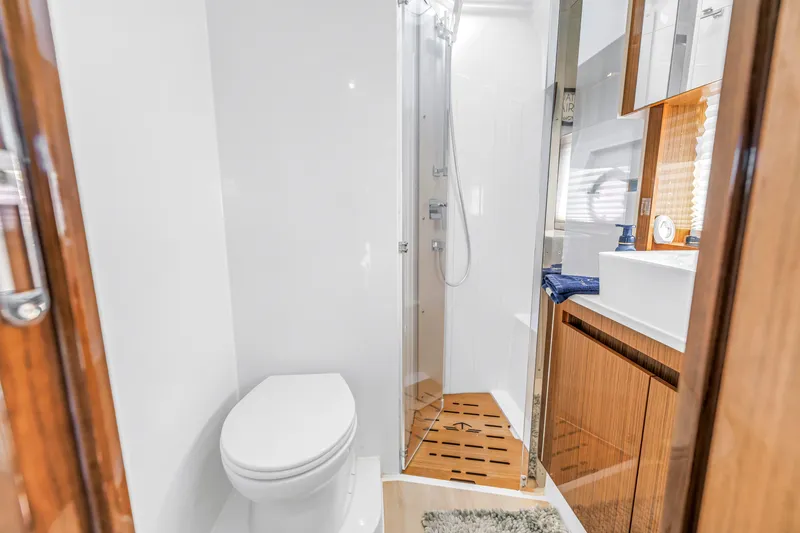 Yacht Photos Pics Modern bathroom in 2020 Sealine C390 yacht with shower, toilet, and wooden cabinetry.
