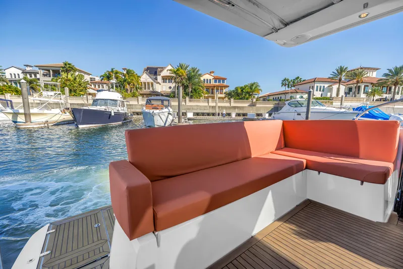  Yacht Photos Pics 2020 Sealine C390 yacht with red seating, docked near luxury waterfront homes.