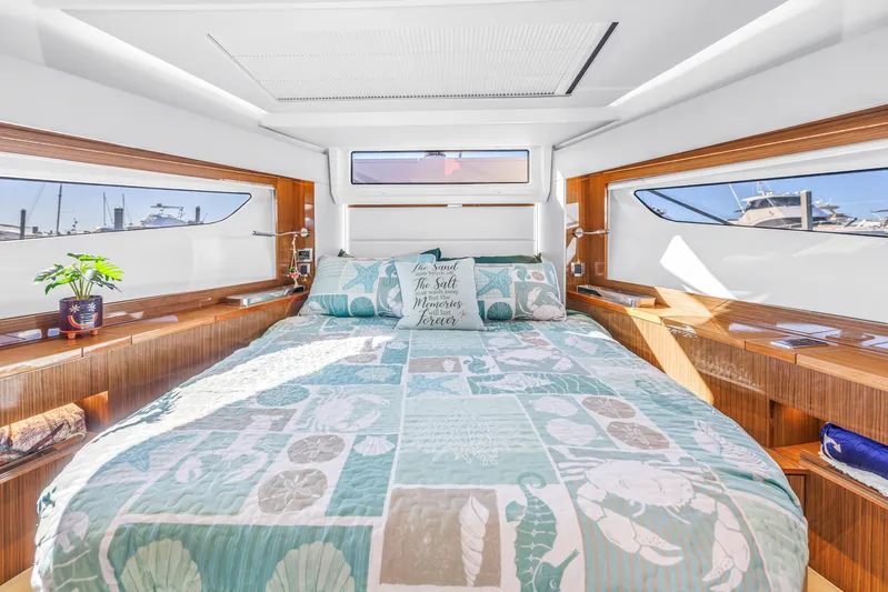  Yacht Photos Pics Luxurious bedroom interior of 2020 Sealine C390 yacht with nautical decor and panoramic windows.