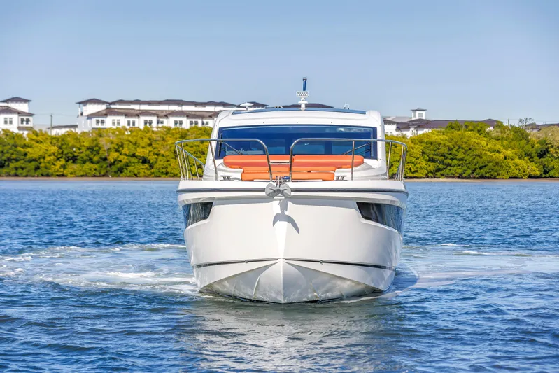 Yacht Photos Pics 2020 Sealine C390 yacht cruising on a sunny day, with scenic waterfront backdrop.