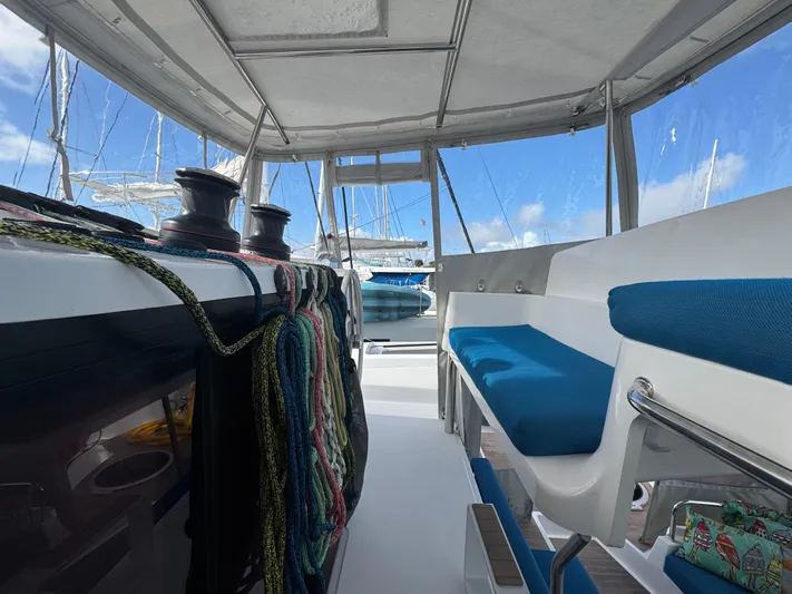 Encantado Yacht Photos Pics Interior view of 2023 NEEL 47 trimaran with blue seating and sailing equipment.