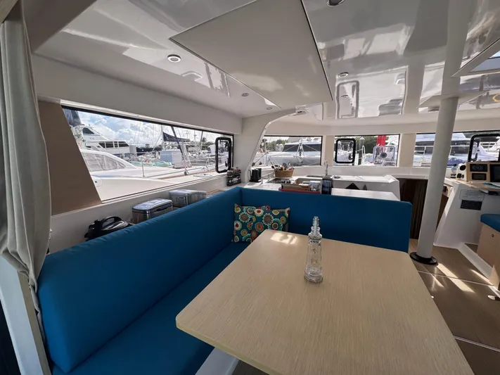 Encantado Yacht Photos Pics Interior of 2023 NEEL 47 catamaran with blue seating and dining area.