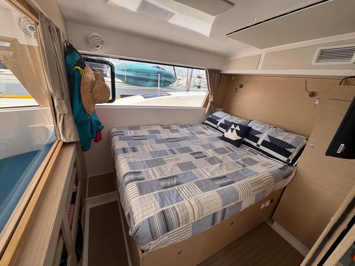 Encantado Yacht Photos Pics Cozy cabin interior of 2023 NEEL 47 trimaran with bed and nautical decor.