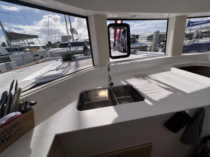 Encantado Yacht Photos Pics Modern NEEL 47 yacht kitchen with dual sink, large windows, and marina view.