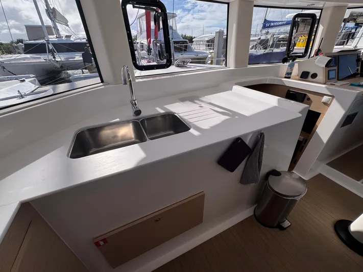 Encantado Yacht Photos Pics Modern NEEL 47 yacht kitchen with dual sink, sleek countertops, and marina view, 2023 model.