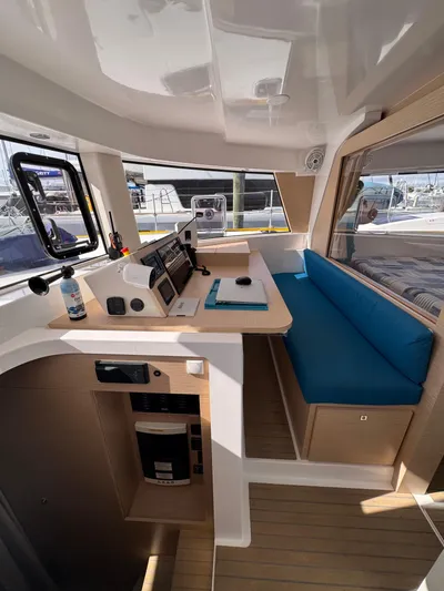 Encantado Yacht Photos Pics Interior of 2023 NEEL 47 trimaran with modern navigation station and blue seating.