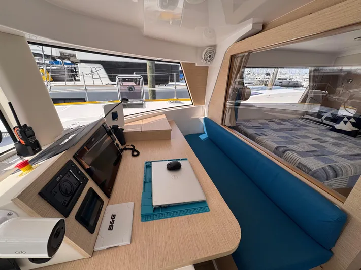 Encantado Yacht Photos Pics Modern NEEL 47 yacht interior with navigation station and cozy seating, 2023 model.