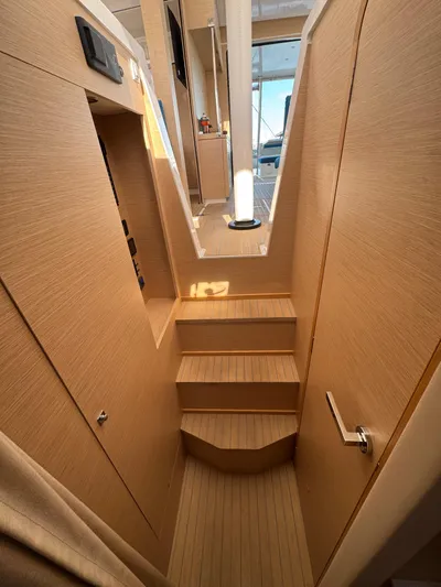 Encantado Yacht Photos Pics Interior of 2023 NEEL 47 yacht, featuring wooden stairs and modern design.