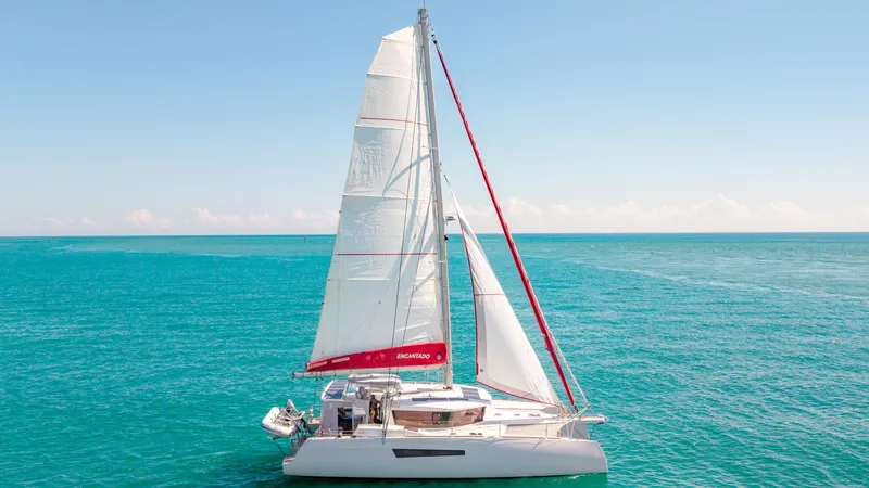 Encantado Yacht Photos Pics Sailing NEEL 47 trimaran on turquoise sea, 2023 model, under clear blue sky.