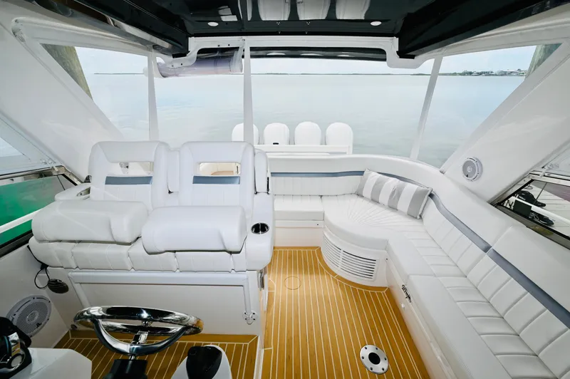  Yacht Photos Pics 2019 Intrepid 475 Sport Yacht interior with white seating and wooden flooring.