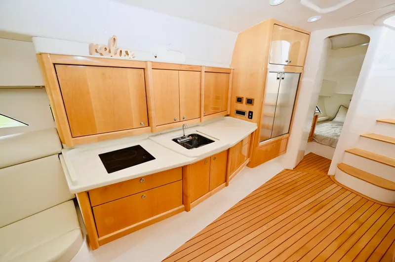  Yacht Photos Pics 2019 Intrepid 475 Sport Yacht interior kitchen with wooden cabinets and modern appliances.