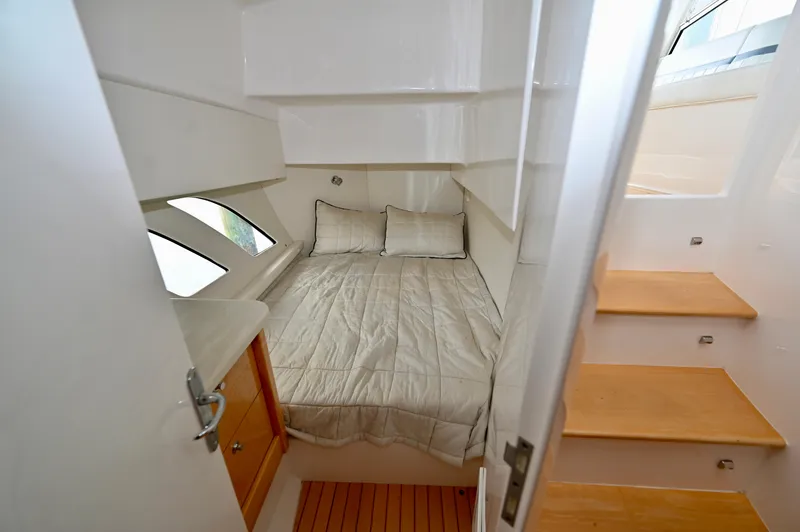  Yacht Photos Pics 2019 Intrepid 475 Sport Yacht cabin with bed, wooden steps, and storage.