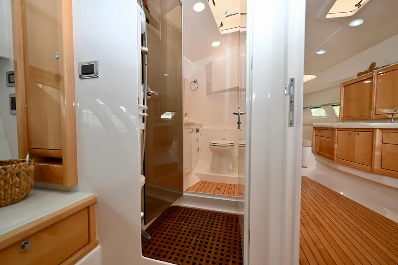  Yacht Photos Pics Luxurious bathroom interior of 2019 Intrepid 475 Sport Yacht with wooden accents and modern fixtures.