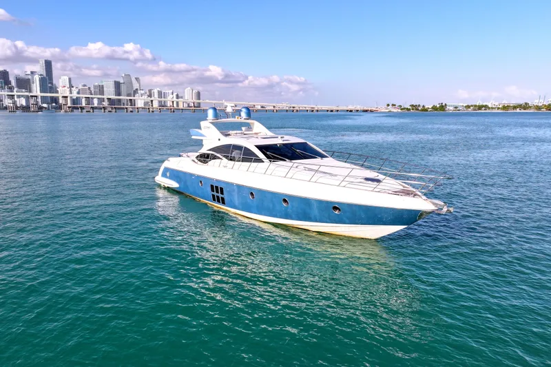  Yacht Photos Pics Luxury 2006 Azimut 68S yacht cruising in clear blue waters near a city skyline.