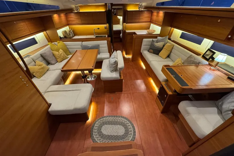 Nine Yacht Photos Pics Luxurious interior of 2016 Dufour 512 Grand Large yacht with elegant seating and warm lighting.