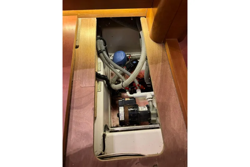Nine Yacht Photos Pics Engine compartment of 2016 Dufour 512 Grand Large sailboat, showing hoses and components.