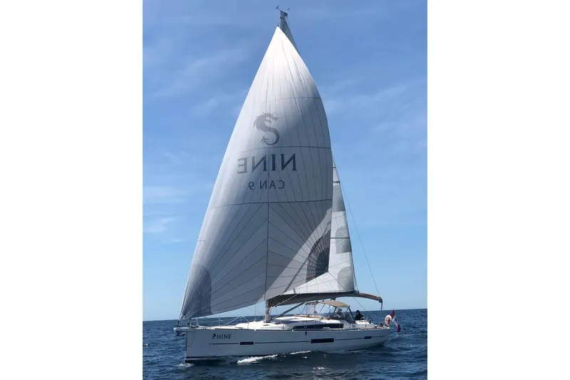 Nine Yacht Photos Pics 2016 Dufour 512 Grand Large sailing on open sea under clear blue sky.