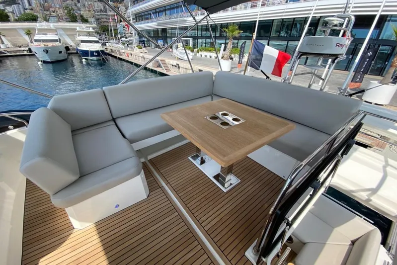 Amarsi Yacht Photos Pics Luxurious 2023 Prestige 520 yacht with elegant seating and wooden table on deck.