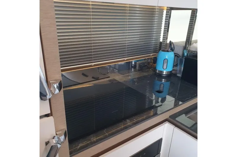 Amarsi Yacht Photos Pics Modern kitchen with sleek black countertop, blue kettle, and blinds, in a 2023 Prestige 520.