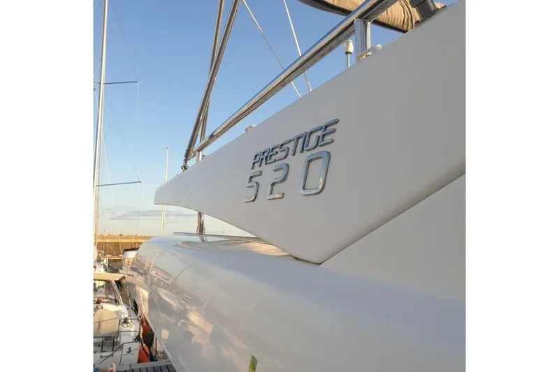 Amarsi Yacht Photos Pics 2023 Prestige 520 yacht side view with logo, docked under clear sky.