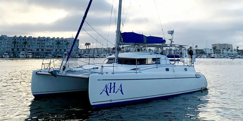 Aha Yacht Photos Pics 1997 Fountaine Pajot Tobago 35 catamaran on calm water, marina in background.