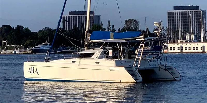 Aha Yacht Photos Pics 1997 Fountaine Pajot Tobago 35 catamaran sailing on calm waters near a cityscape.