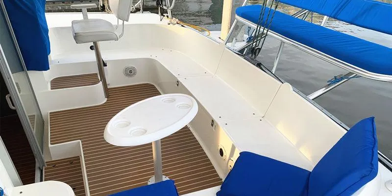 Aha Yacht Photos Pics 1997 Fountaine Pajot Tobago 35 yacht cockpit with blue cushions and a small table.