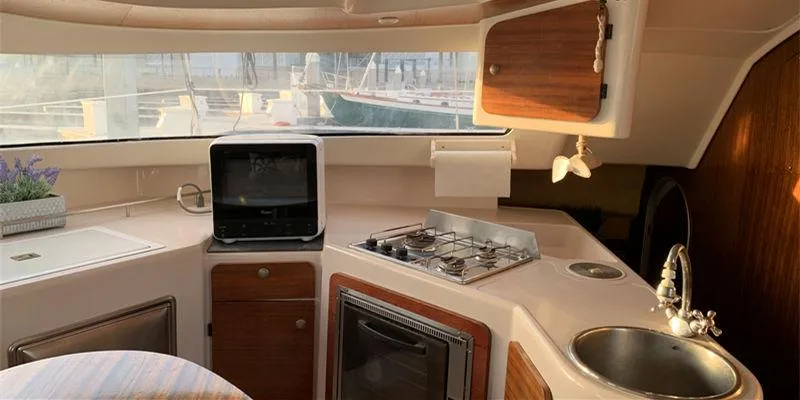 Aha Yacht Photos Pics Interior of 1997 Fountaine Pajot Tobago 35 catamaran kitchen with stove, sink, and storage.