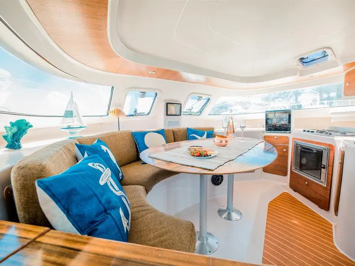 Aha Yacht Photos Pics Luxurious interior of 1997 Fountaine Pajot Tobago 35 catamaran with cozy seating and modern amenities.