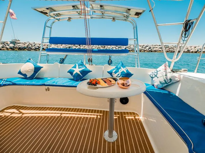 Aha Yacht Photos Pics 1997 Fountaine Pajot Tobago 35 catamaran with blue seating, table, and nautical-themed pillows.