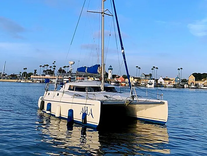 Aha Yacht Photos Pics 1997 Fountaine Pajot Tobago 35 catamaran sailing in a calm harbor.