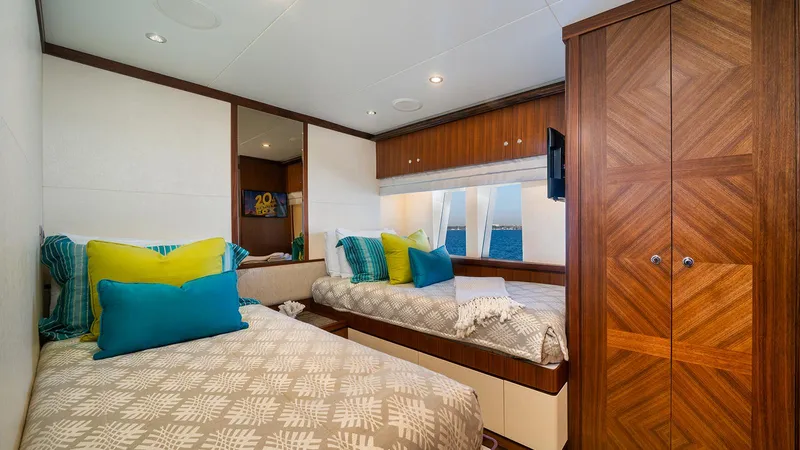 Sea N Sea Yacht Photos Pics Luxurious 2016 Ocean Alexander Skylounge bedroom with twin beds, vibrant pillows, and wooden cabinetry.