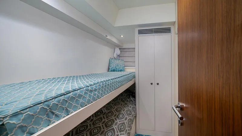 Sea N Sea Yacht Photos Pics 2016 Ocean Alexander Skylounge cabin with single bed, patterned bedding, and wooden door.
