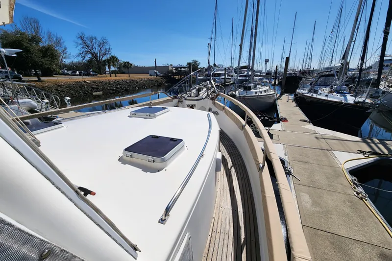 Part Of The Plan Yacht Photos Pics 1990 Grand Banks 46 Classic yacht docked at marina under clear blue sky.