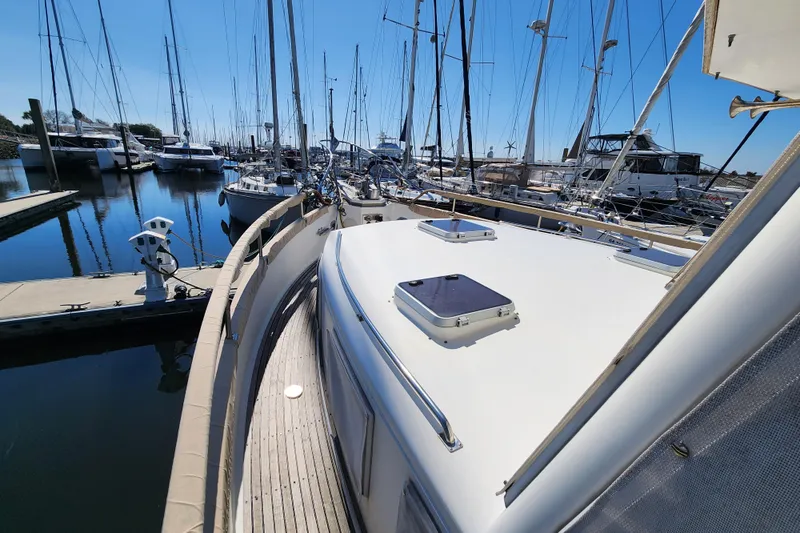 Part Of The Plan Yacht Photos Pics 1990 Grand Banks 46 Classic yacht docked in a marina, surrounded by sailboats.