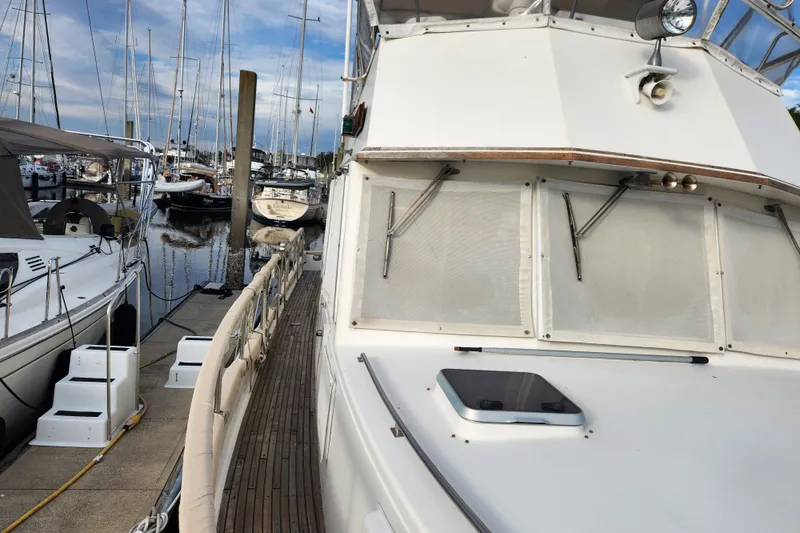 Part Of The Plan Yacht Photos Pics 1990 Grand Banks 46 Classic yacht docked at marina with other boats.