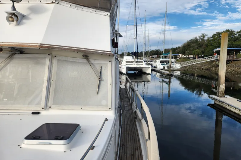 Part Of The Plan Yacht Photos Pics 1990 Grand Banks 46 Classic yacht docked at marina, calm water reflections.