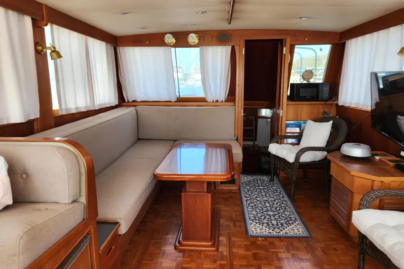 Part Of The Plan Yacht Photos Pics Interior of 1990 Grand Banks 46 Classic yacht with elegant wood furnishings and cozy seating.