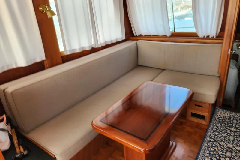 Part Of The Plan Yacht Photos Pics Interior of 1990 Grand Banks 46 Classic yacht with cozy seating and wooden table.