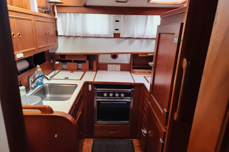 Part Of The Plan Yacht Photos Pics Cozy kitchen in 1990 Grand Banks 46 Classic yacht with wooden cabinetry and modern appliances.