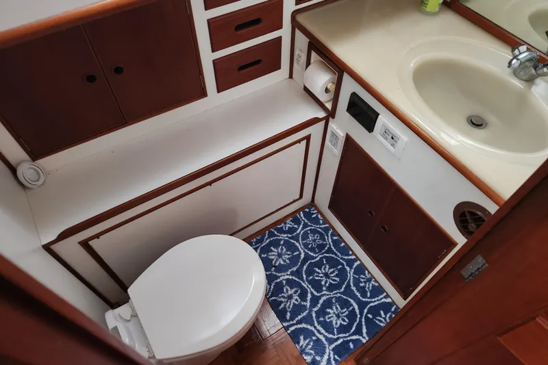 Part Of The Plan Yacht Photos Pics Bathroom interior of 1990 Grand Banks 46 Classic yacht with sink, toilet, and storage cabinets.