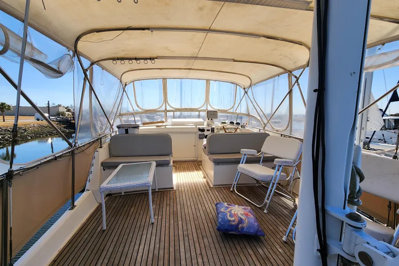 Part Of The Plan Yacht Photos Pics 1990 Grand Banks 46 Classic yacht interior with seating and helm, docked by calm waters.